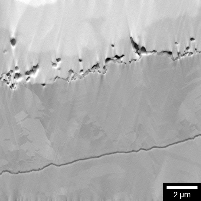 Visible microcracks at FIB-polished interface between solder bump and IMC layer.