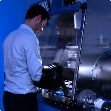Researcher prepping battery sample in inert gas glove box
